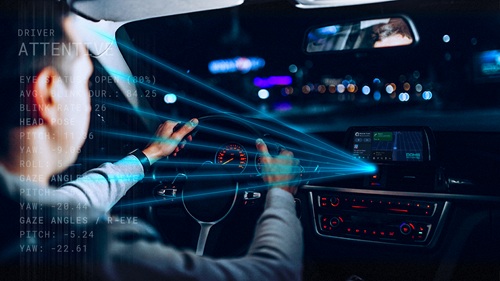 Driver interacting with dashboard in a modern car at night, blue driver monitoring system beams