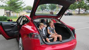 Family car 7 Tesla Model S Red doors open and two children sitting in rear seats
