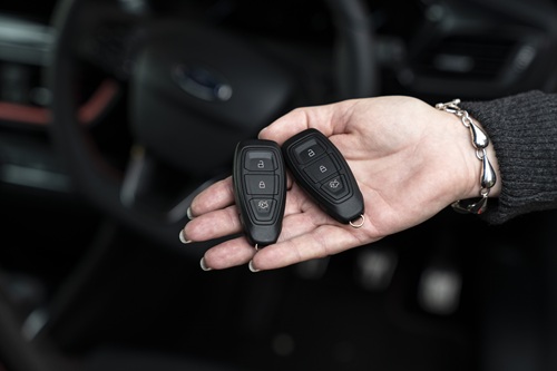 Female-hand-holding-two-sets-of-keyless-car-keys