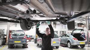 MOT 2 MOT inspector checking the underside of a raised car