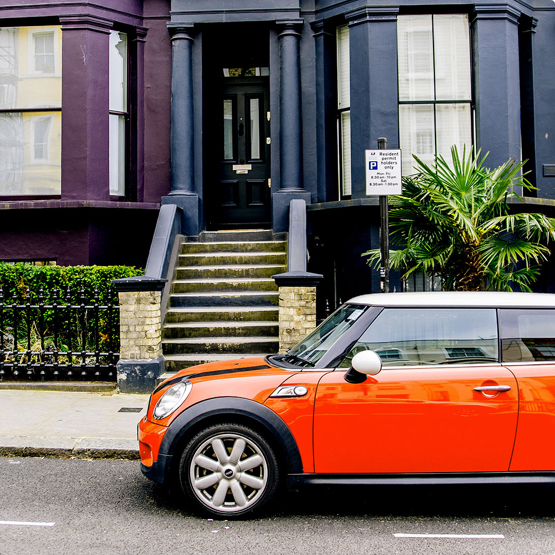 Orange Mini parked outside a row of Georgian townhouses
